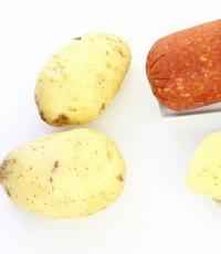 Ocvrt krompir s kuhano klobaso, grahom in čebulo v ponvi Dušen krompir s klobasami